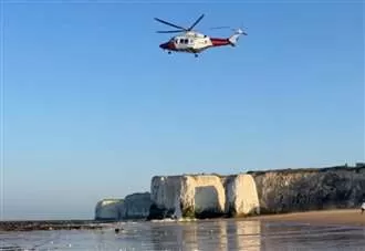 Helicopter crew rescues person stranded on cliffs near beach